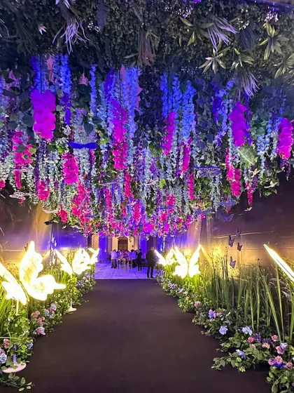 We believe in creating moments of pure whimsy and enchantment. This magical sangeet entrance features a walkway lined with glowing butterflies and a ceiling of cascading purple and pink wisteria, promising a night of fantasy. 🦋