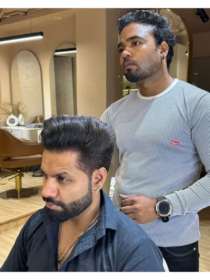 A close-up of a client's transformation. The high-volume hairstyle and perfectly groomed beard make a strong style statement.