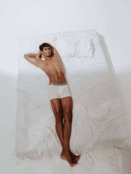 A slightly different angle of the overhead bed shot, this image offers a more direct and engaging perspective. The styling is stripped back to the essential product, embodying the "My Calvins" concept.