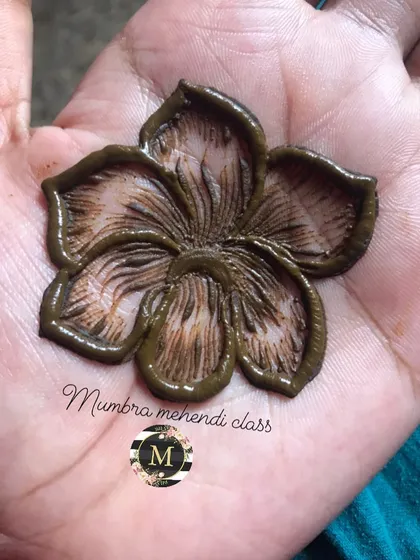 A close-up of a 3D hibiscus flower. The thick application of henna gives it this amazing raised effect.