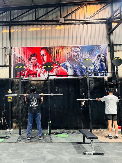 Two athletes warming up with back squats. Our gym is designed to accommodate multiple people training at once, fostering a sense of shared effort and community.