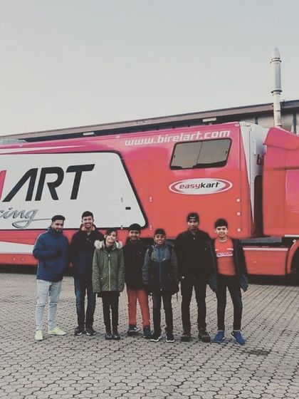 Our drivers standing in front of the official Birel ART Racing truck in Italy, experiencing the professional European racing environment.
