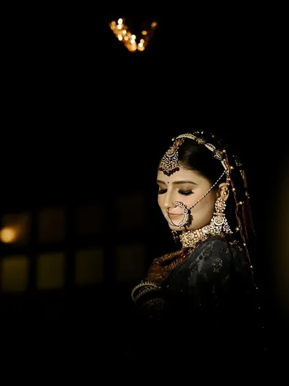 I love using shadows and light to create drama. This bridal portrait focuses on the bride's calm expression and the intricate details of her nath and jewellery, creating a timeless, cinematic feel before the main ceremony.