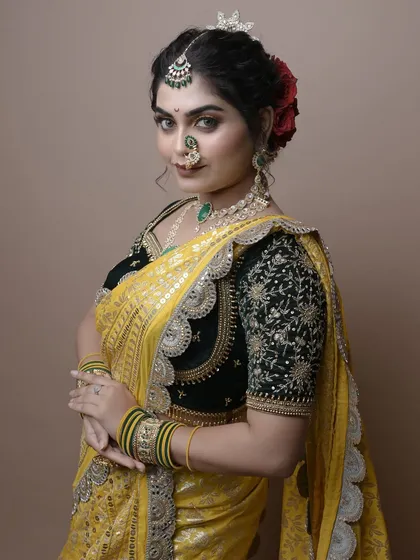 A confident pose showcasing the complete look created by a student, from the makeup and hair to the jewelry and saree.