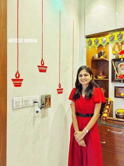 Simple yet elegant hanging diya murals painted next to a home mandir. This is a great example of how small, custom wall art can enhance a space for special occasions like Diwali.