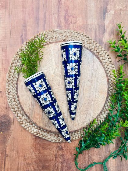 A close-up of our hand-painted ceramic conical wall planters in a dark blue and white design. These are perfect for creating a stylish vertical garden with your favorite water plants.