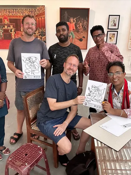 Two international visitors proudly hold up their completed signature art pieces at my exhibition in Colombo.