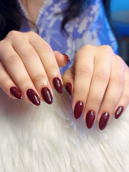 A classic deep red manicure on almond-shaped nails.