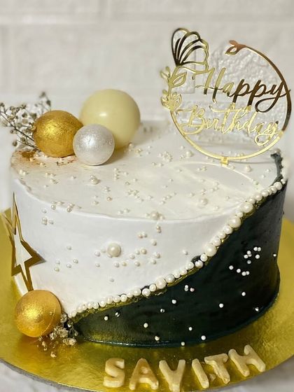 A still shot of the elegant black and white cake, showing off the gold accents.