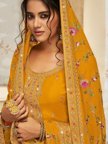 This mustard salwar kameez is like a ray of sunshine. The heavy thread embroidery and floral dupatta make it a cheerful and bright choice for any celebration.