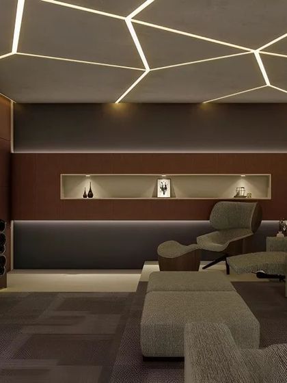 This home theater boasts a unique geometric lighting pattern on the ceiling. The comfortable lounge chairs and dark color scheme are designed for maximum viewing comfort.