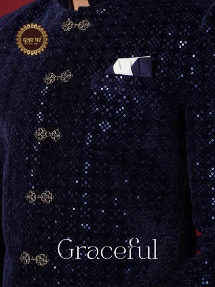 Graceful. A detailed shot of a navy blue velvet jacket, highlighting the unique buttons and sequined texture.