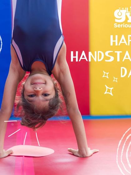 Happy Handstand Day. A young gymnast smiles 정책 upside down, perfectly balanced. Handstands are a fantastic exercise for building core strength, balance, and body control.