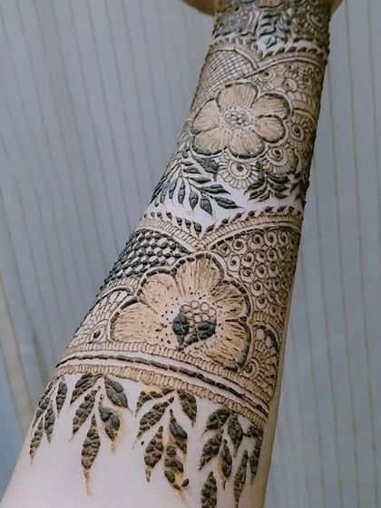 A close-up on the forearm portion of a bridal design, highlighting the beautiful floral bands and leafy vine patterns.