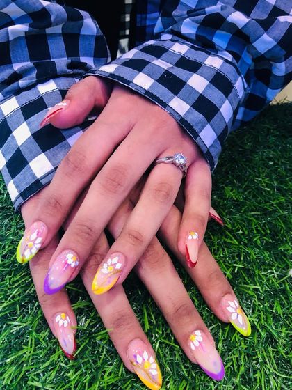 A vibrant and colorful set with multi-colored tips and daisy art, perfect for summer.