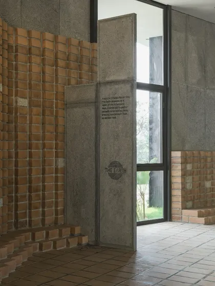 An interior detail at 'The Earth' showing the junction of the textured CSEB wall and a smooth granite-clad panel, which also serves as a door, showcasing our attention to material interplay.