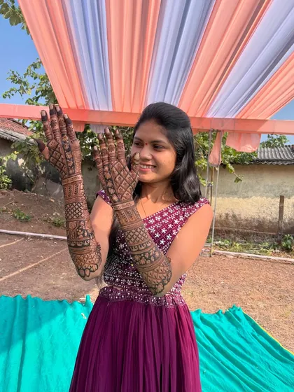 A joyful pose capturing the beautiful bridal henna. The design combines both figurative and traditional pattern work.