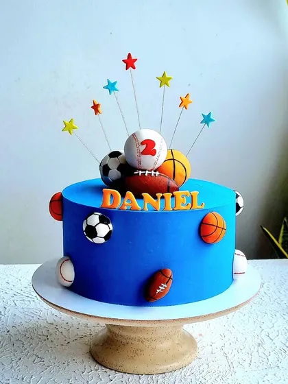 A full view of the blue sports ball-themed cake on its stand.