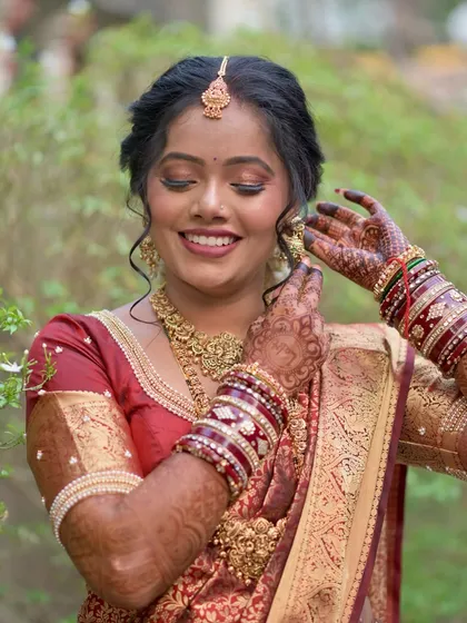 Another beautiful shot of the bride getting ready, her smile radiant as she puts on her earrings.