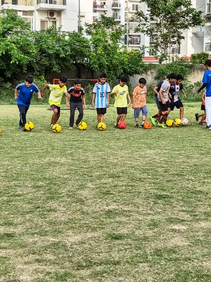Lined up and ready to go. Players each with a ball, preparing to start a fundamental dribbling and ball mastery drill.
