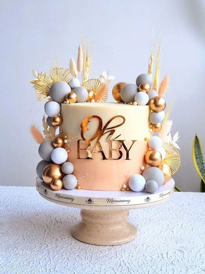 A full view of the elegant, modern baby shower cake on its stand.