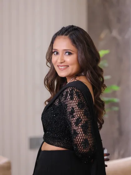 A smiling portrait showing off her Sangeet look. The braided hairstyle and glowing makeup create a look that is both trendy and timeless.