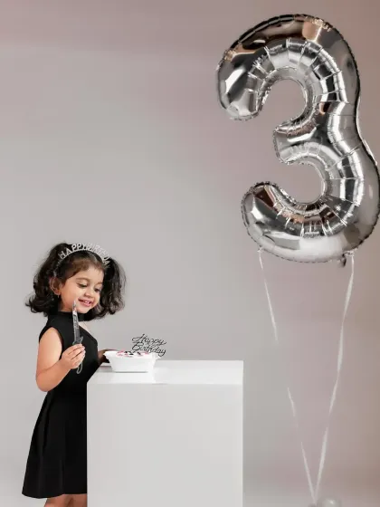 A little princess enjoying her birthday treat. This shot captures the quiet joy of a milestone celebration.