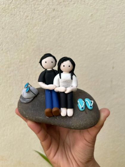 A simple, sweet moment captured in clay. This miniature features a couple sitting together on a stone, perfect as a keepsake to celebrate a relationship or a special memory.