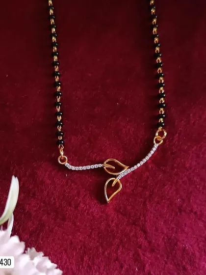 This elegant mangalsutra features a delicate leaf motif pendant. Crafted from 92.5 silver with gold plating, it's a beautiful and subtle piece for the modern woman.