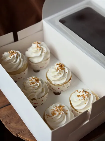 A close up shot showing the fluffy frosting and delicate gold sprinkles on my classic vanilla cupcakes.