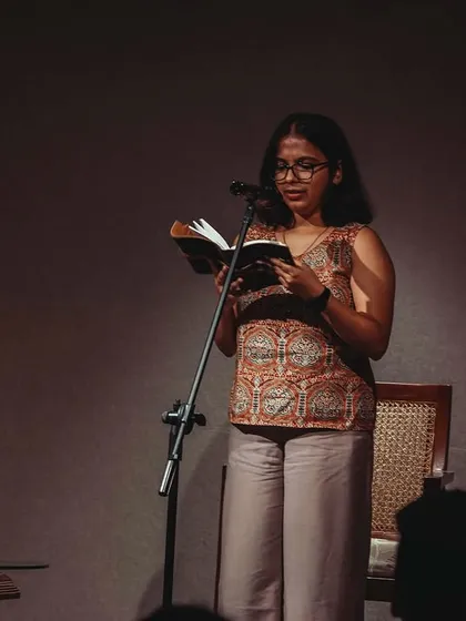 A poet lost in her words during a performance. Our stage is an intimate space, creating a powerful connection between the artist and the audience.