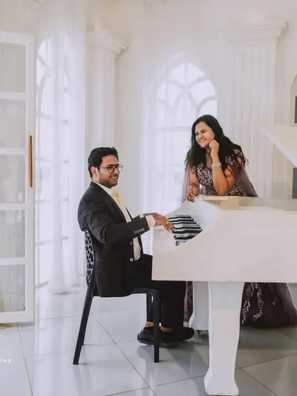 An all-white, classic European-style studio sets the stage for pure romance. The grand piano and crystal chandelier add a touch of musical elegance to this couple's pre-wedding photos.