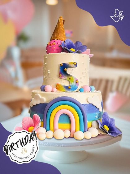 A whimsical cake for a 5th birthday, featuring a rainbow, an ice cream cone, and flowers. This colorful and creative design is full of fun and imagination.