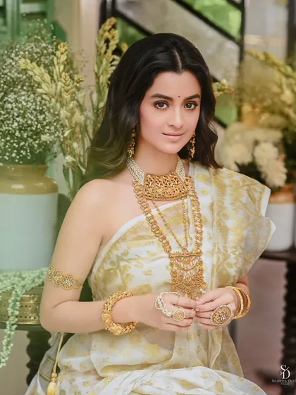 A portrait of actress Darshana Banik for Sananda's 'Noboborsho' issue. She holds a garland of 'shiuli' flowers, adding a touch of cultural authenticity and softness to the festive look.