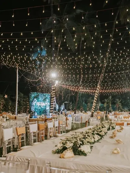 A breathtaking view of an outdoor reception with a canopy of thousands of fairy lights. This kind of lighting installation transforms the entire venue and creates an unforgettable, magical atmosphere.