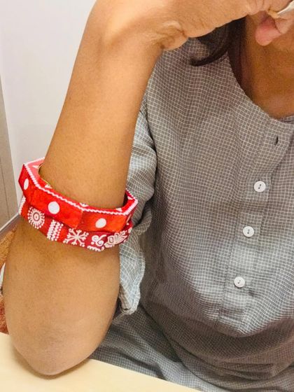 Another look at the Maati bangles, showing how they can be pushed up the arm for a different style. The hand-painted white details pop against the red base.