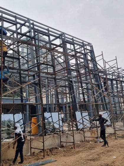 A wide shot of the steel structure, capturing the scale of the construction and the manpower involved in bringing the design to life.