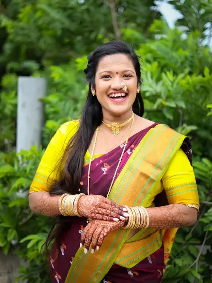 Capturing genuine moments is key to a great portfolio. This candid shot of a bride in a traditional saree shows her joyful laugh during an outdoor shoot.