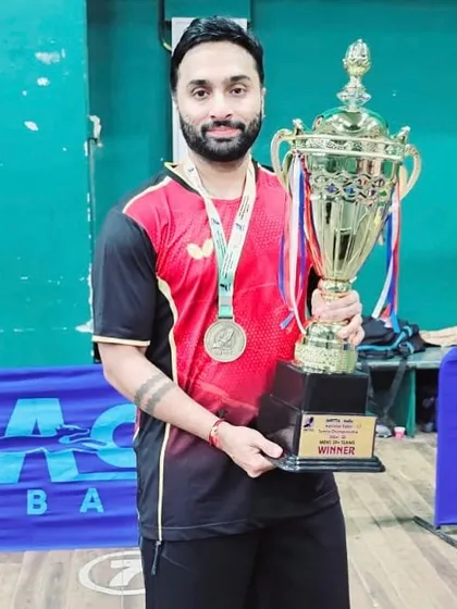 Our commitment to the sport extends to all age groups. We celebrate our veteran player, Suraj Chandrashekhar, holding the winner's trophy after securing a National Championship title in the 40+ age category.
