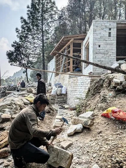A stonemason carefully chisels a block of local stone on our Uttarakhand site. This ancient craft is at the heart of our mountain projects, with every stone shaped and placed by hand to create enduring walls.