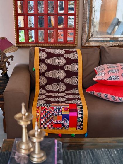 A runner created for a client, featuring a Kalamkari fabric with Kathakali mask images. The trim is a handcrafted patchwork made from precious scraps of tribal embroidery and mirror-work from my vintage stash.