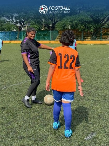 Our coach provides direct feedback to a young player during a girls' U15 trial session, highlighting our hands-on approach.