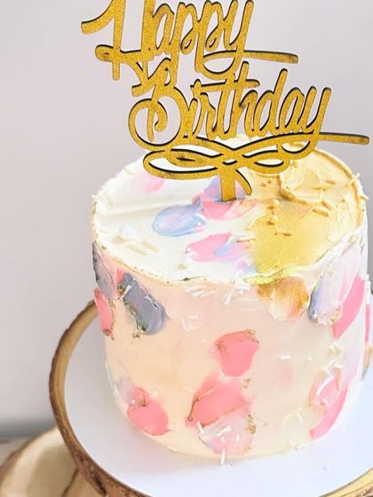 A close-up of the abstract painted buttercream cake, showing the beautiful blend of colours and the touch of gold.