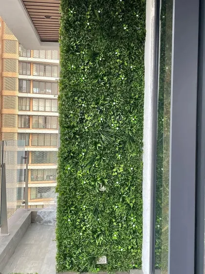 Even a small high-rise balcony can become a green oasis. This installation shows a dense, multi-textured artificial vertical garden that provides a beautiful view and requires zero maintenance, perfect for busy city life.