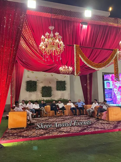 Guests relaxing in a comfortable lounge area, with a large screen in the background for presentations or live feeds.