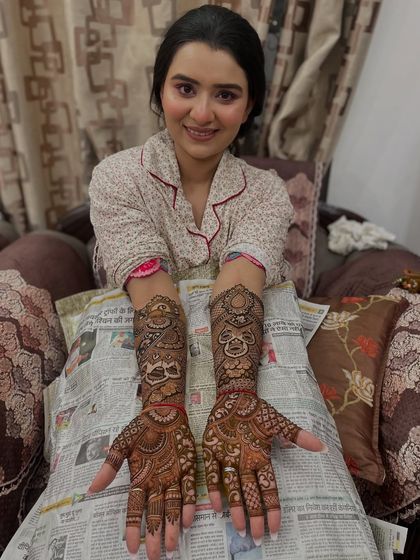The bride proudly displays her full-sleeve mehandi, a testament to the hours of detailed work.