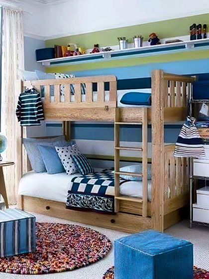 A classic wooden bunk bed in a room with a cheerful blue and green striped wall. This design is timeless and provides a cozy sleeping arrangement for siblings, with plenty of space for play.
