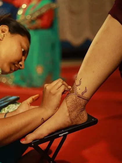 The art in motion. Here I am, focused on creating a detailed design on a client's foot, ensuring every line is perfect. We provide a comfortable setup for our clients at any venue.