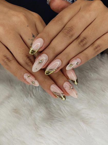 A glamorous set featuring gold chrome tips and delicate gold line work. The tiny, sparkling rhinestones and starburst details add an extra layer of elegance.