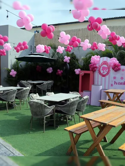 A chic and stylish Barbie-themed outdoor seating arrangement. The pink floral balloon clusters create a beautiful canopy for guests.